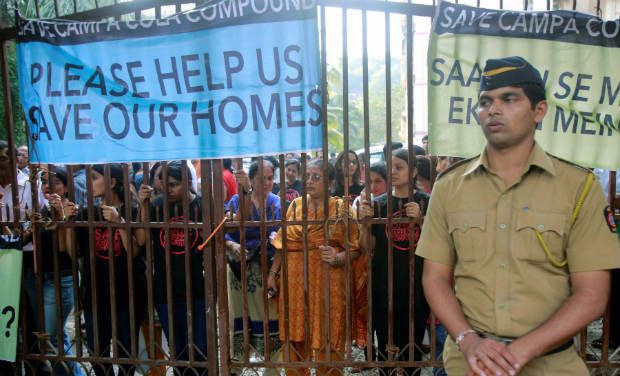 A policeman stands in front of a gate blocked by residents of Mumbai's Campa Cola housing colony in Mumbai on Tuesday. A policeman stands in front of a gate blocked by residents of Mumbai's Campa Cola housing colony in Mumbai on Tuesday.